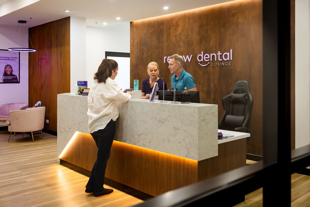 Modern dental office interior features warm wood paneling, LED lighting, and a sleek reception desk with minimalist design.