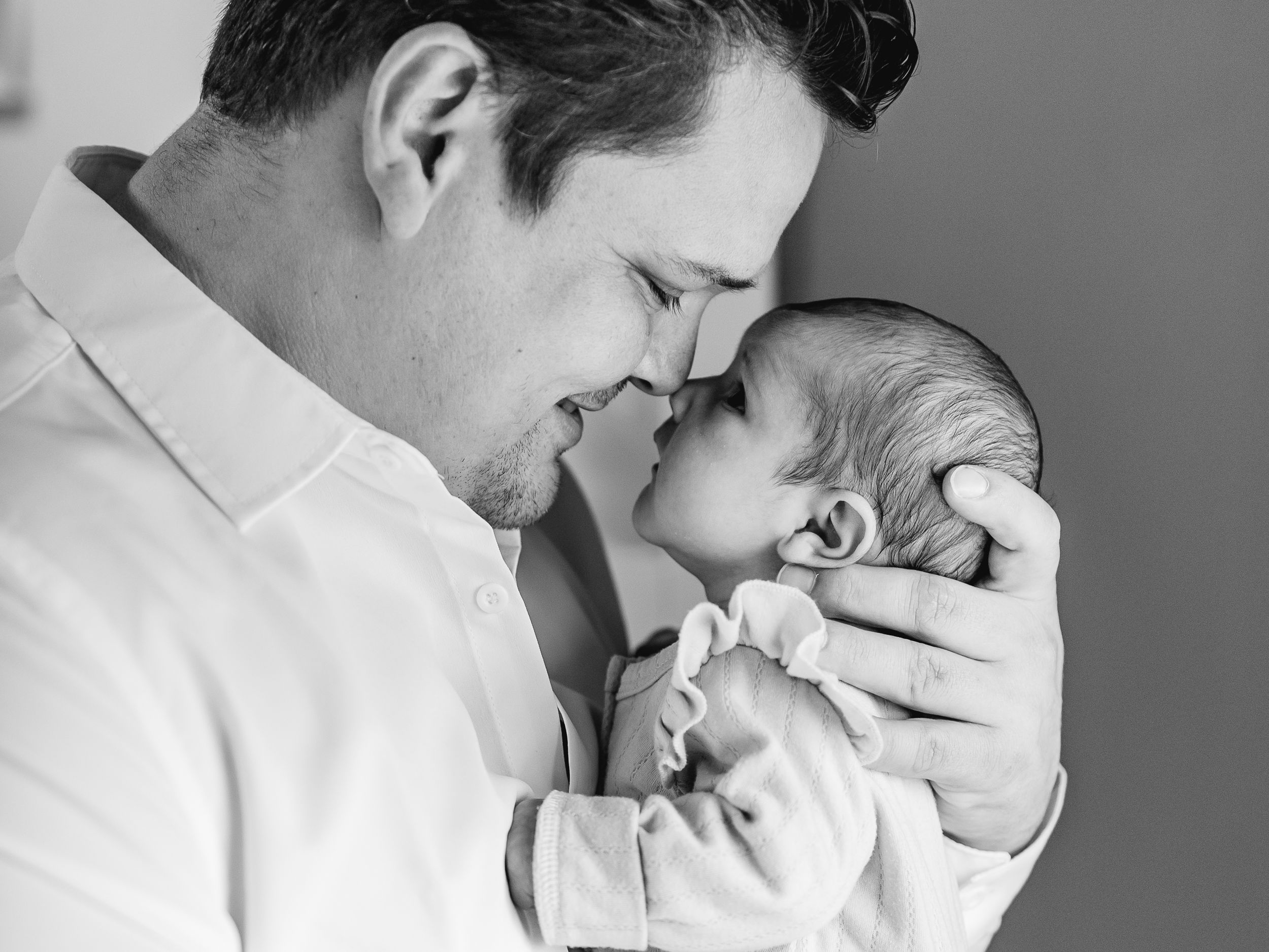 Black and white intimate portrait of tender parent-child bonding moment.