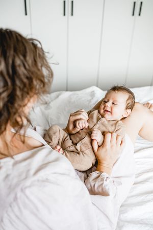 Intimate black and white photos of a sleeping baby in soft white bedding.