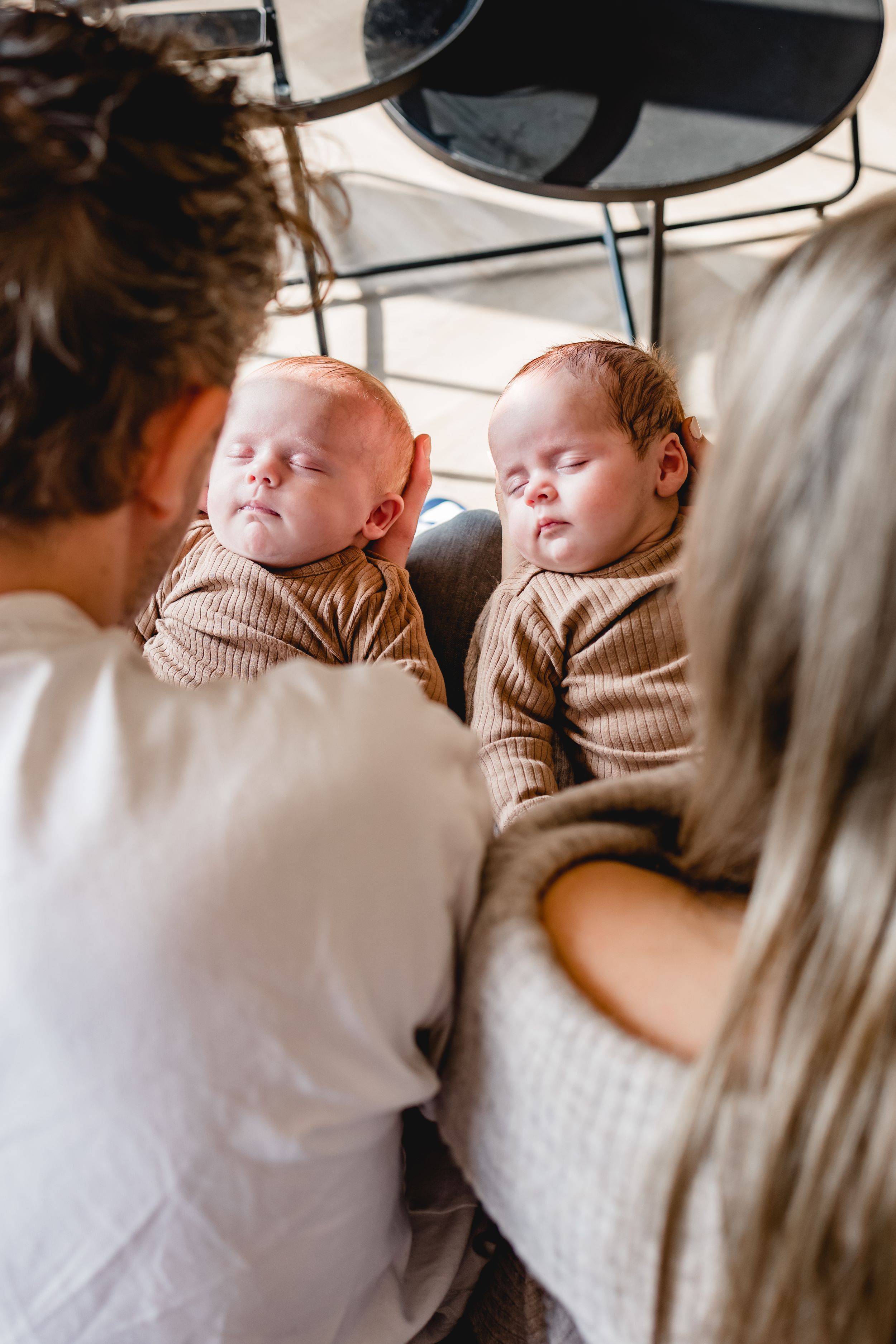 Sweet candid moments of a baby sleeping in cozy brown knitwear.