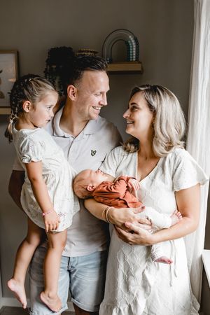 A loving family moment captured in a series of tender interactions with their newborn baby.