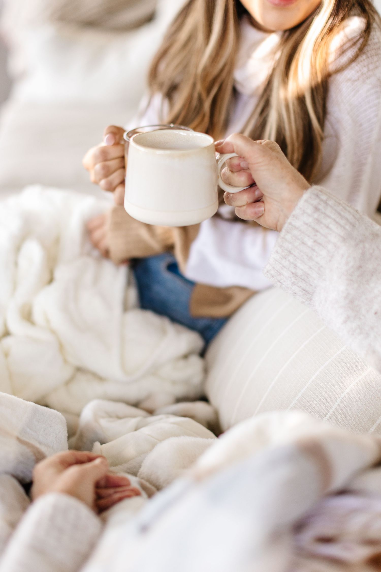 Cozy scene with white knit sweaters and soft textures.
