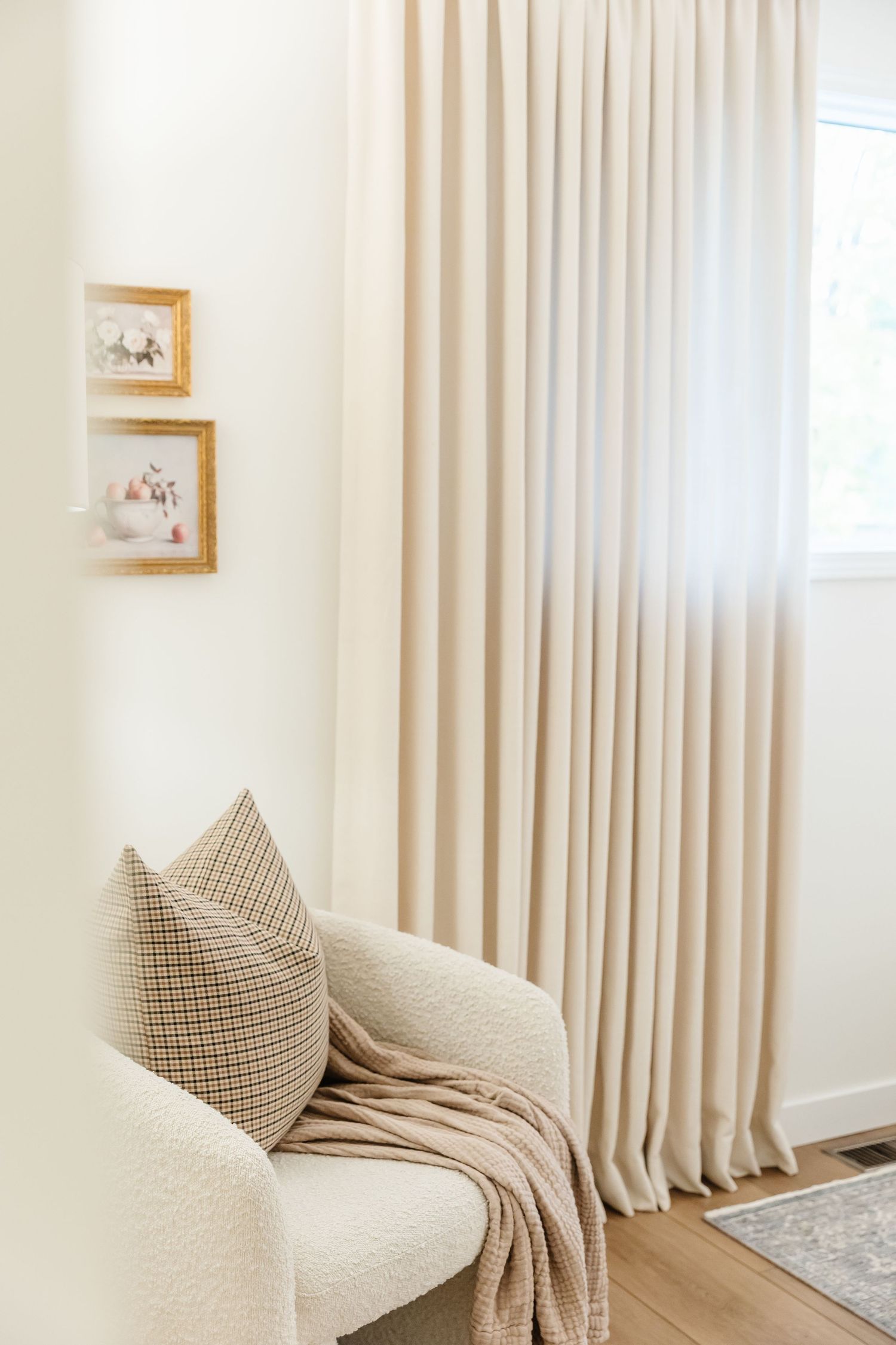 Minimalist living room with cream sofa, textured throw pillow, and beige curtains in natural light photographed by a Kelowna photographer
