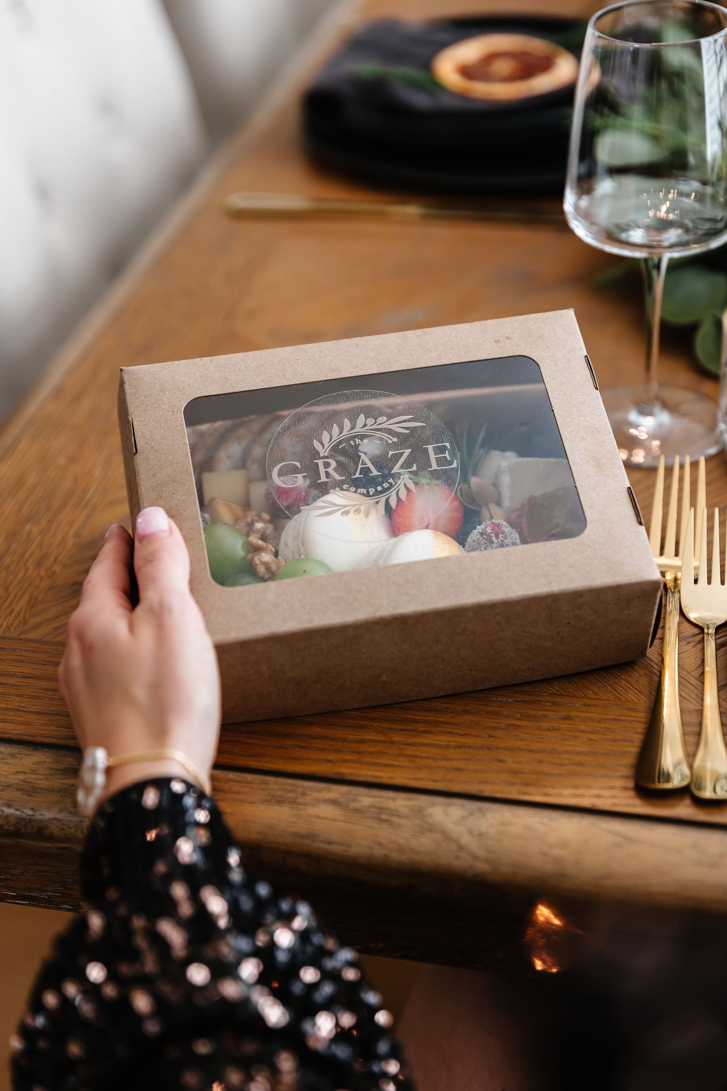 Kraft paper gift boxes arranged on a wooden table with holiday place settings.