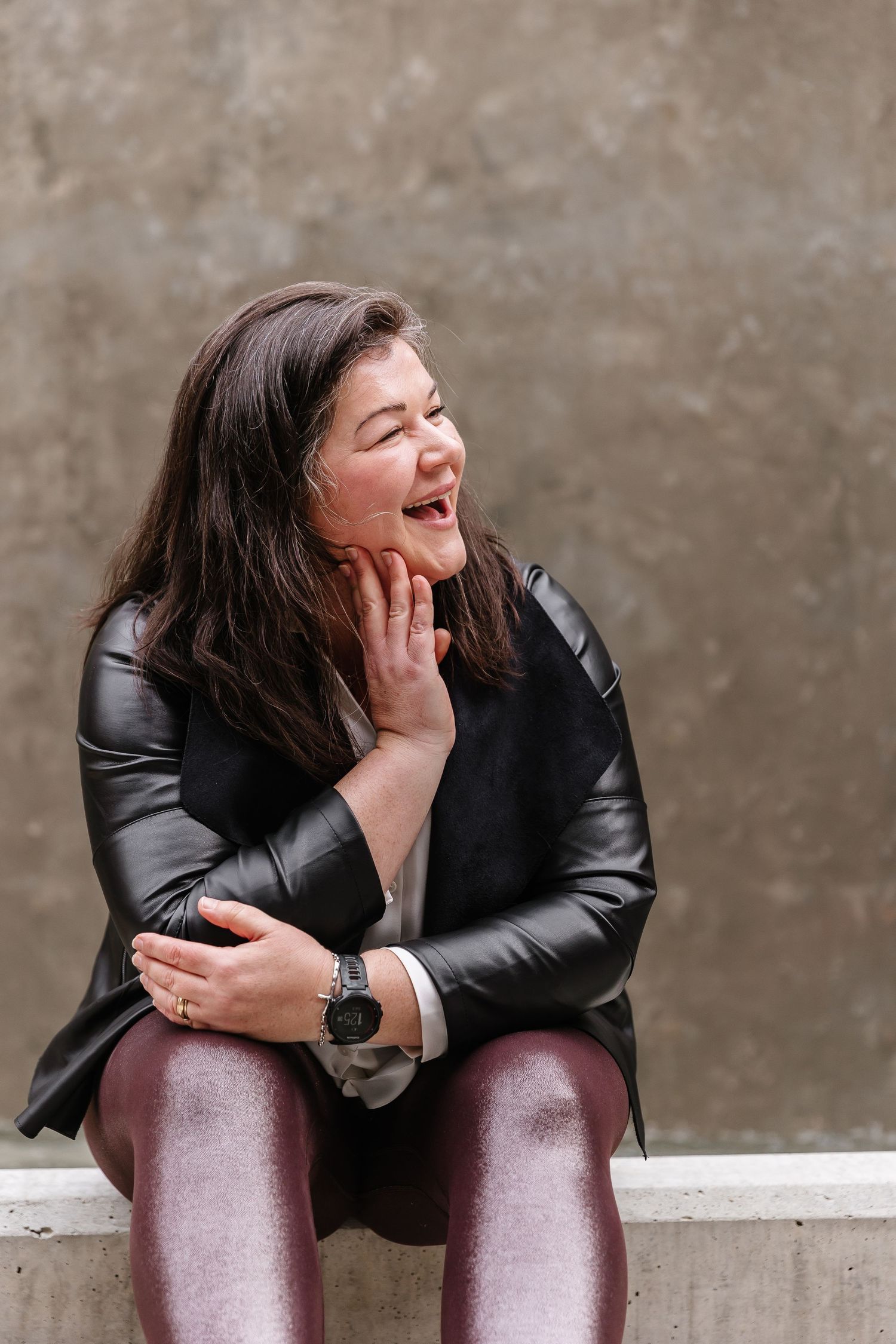 Candid laughing moments captured against a neutral wall background.