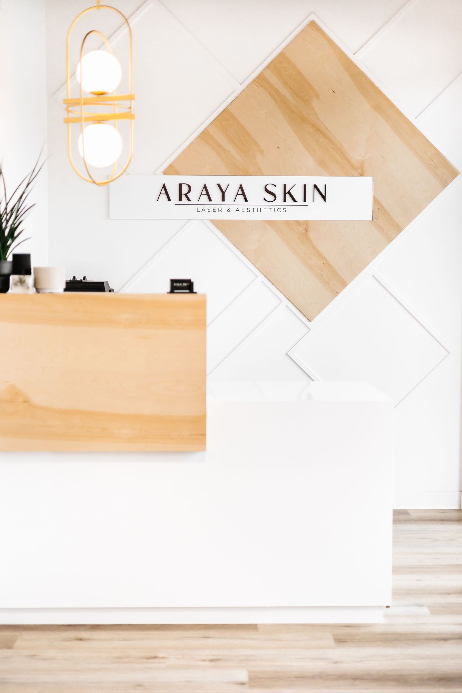 Modern minimalist spa interior with white walls and wooden accents featuring Araya Skin branding.