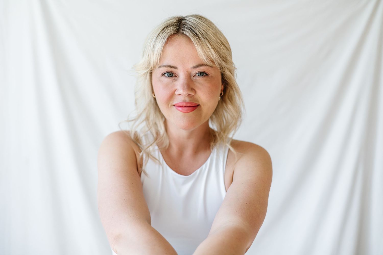 Minimalist studio photography with white backdrop and casual styling.