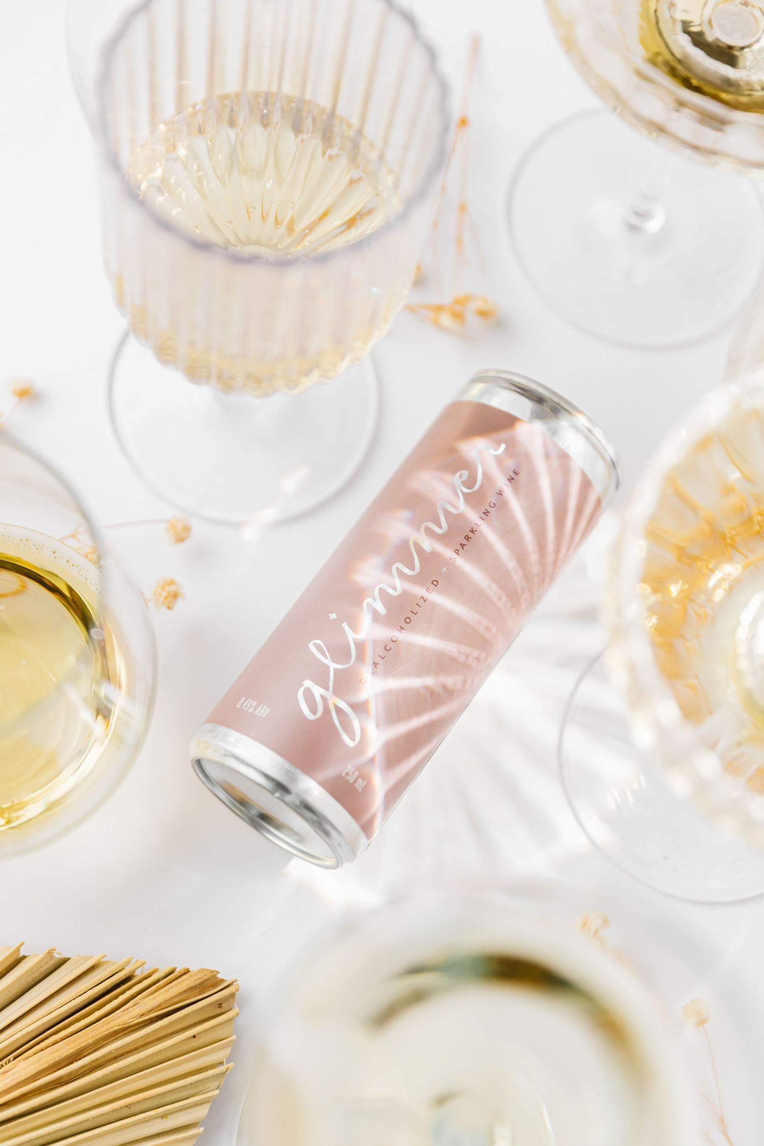 Elegant champagne glasses filled with sparkling wine and gold confetti on a bright white background.