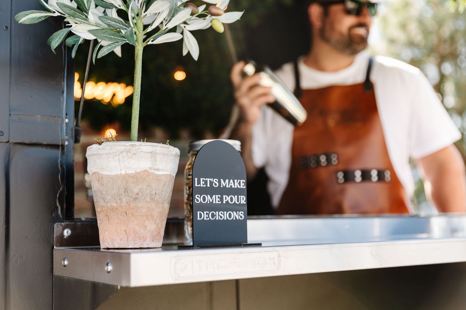 A modern coffee shop counter with baristas preparing drinks and serving customers through a window.