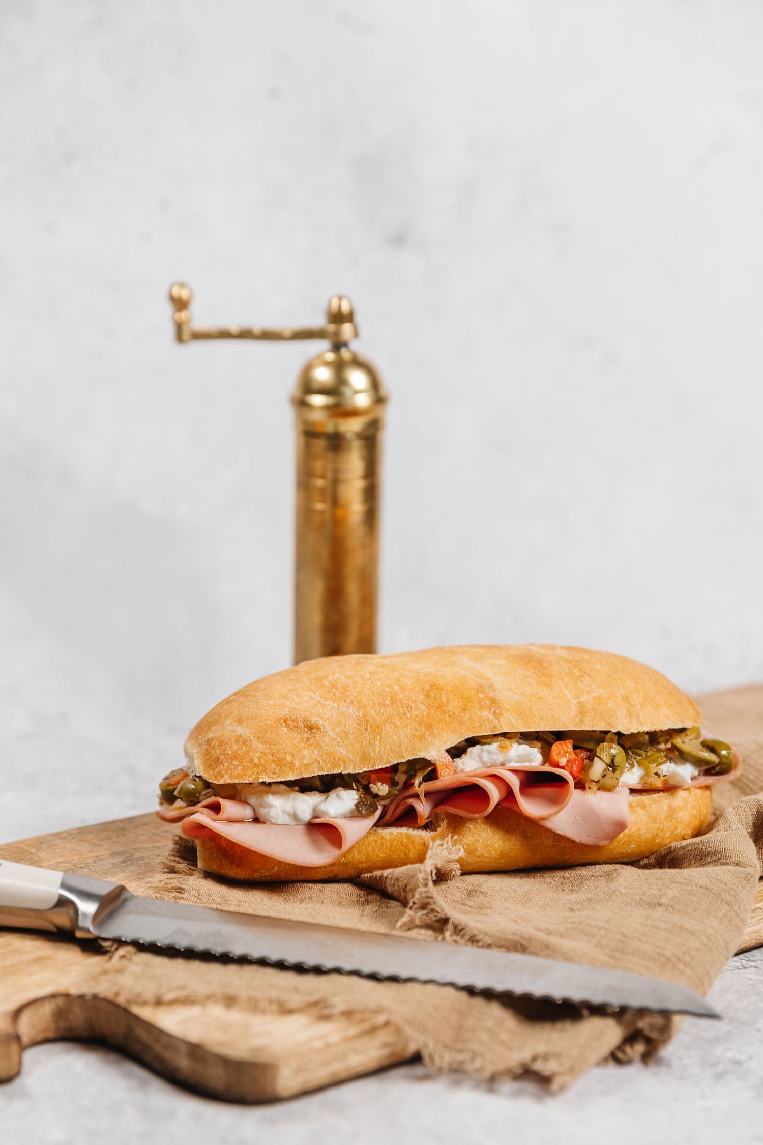 Fresh deli sandwiches on wooden cutting boards with meat and vegetables arranged in a row for a branding photoshoot in West Kelowna, BC.