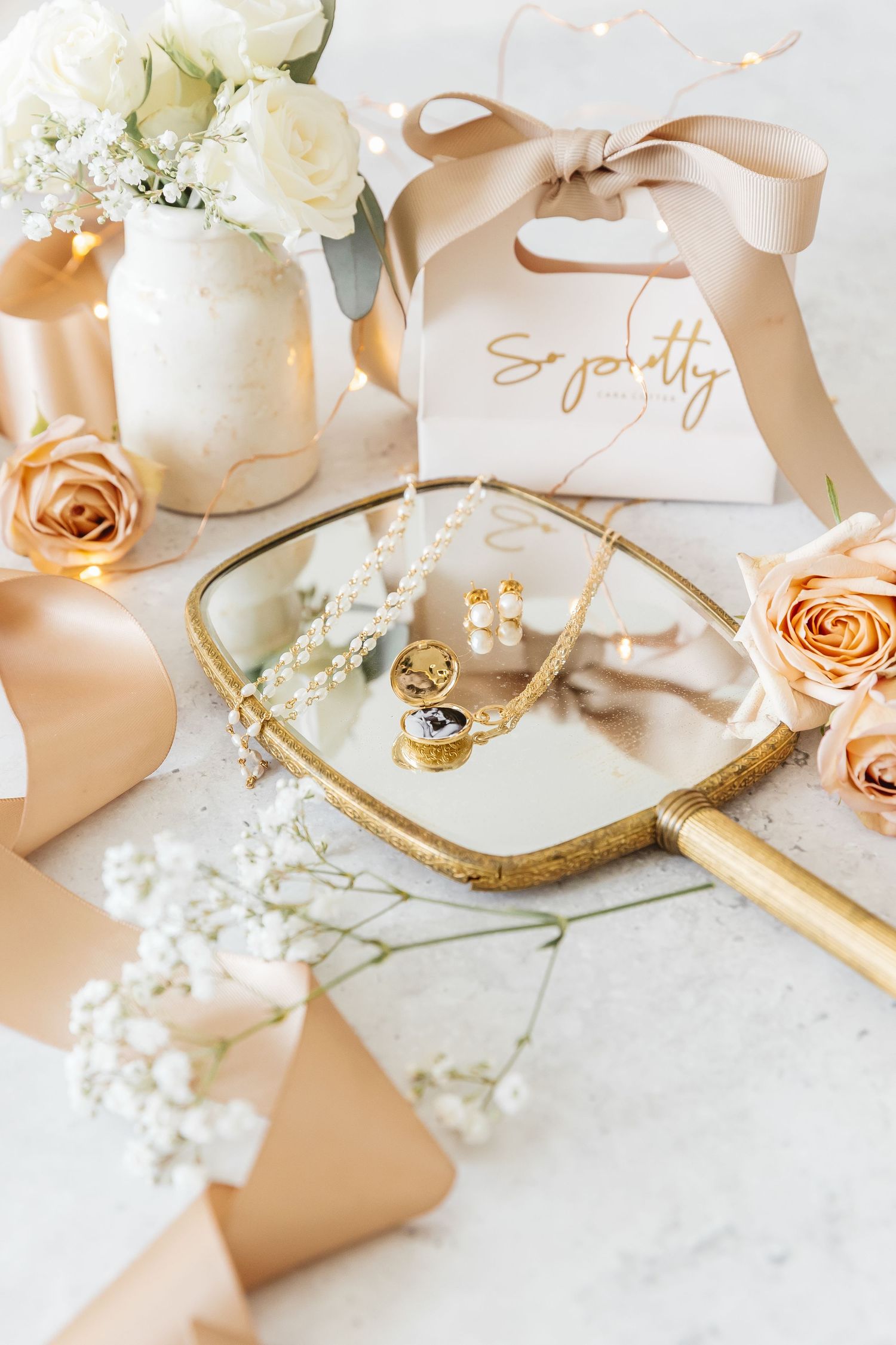 Wedding accessories in blush pink and gold tones with white flowers photographed by a Kelowna photographer for wedding detail shots