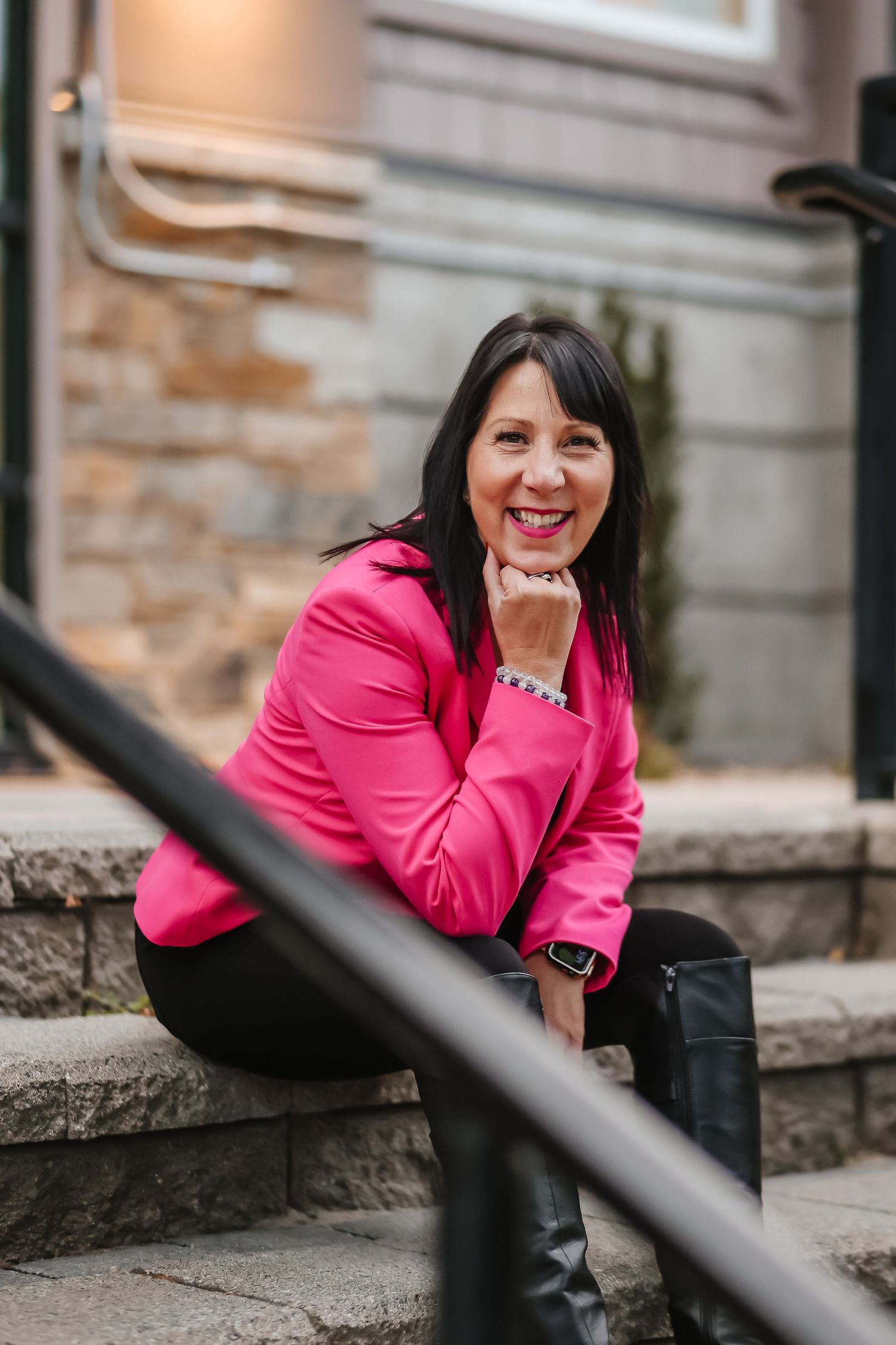 Fashion portrait series featuring bright pink blazer against stone wall backdrop.
