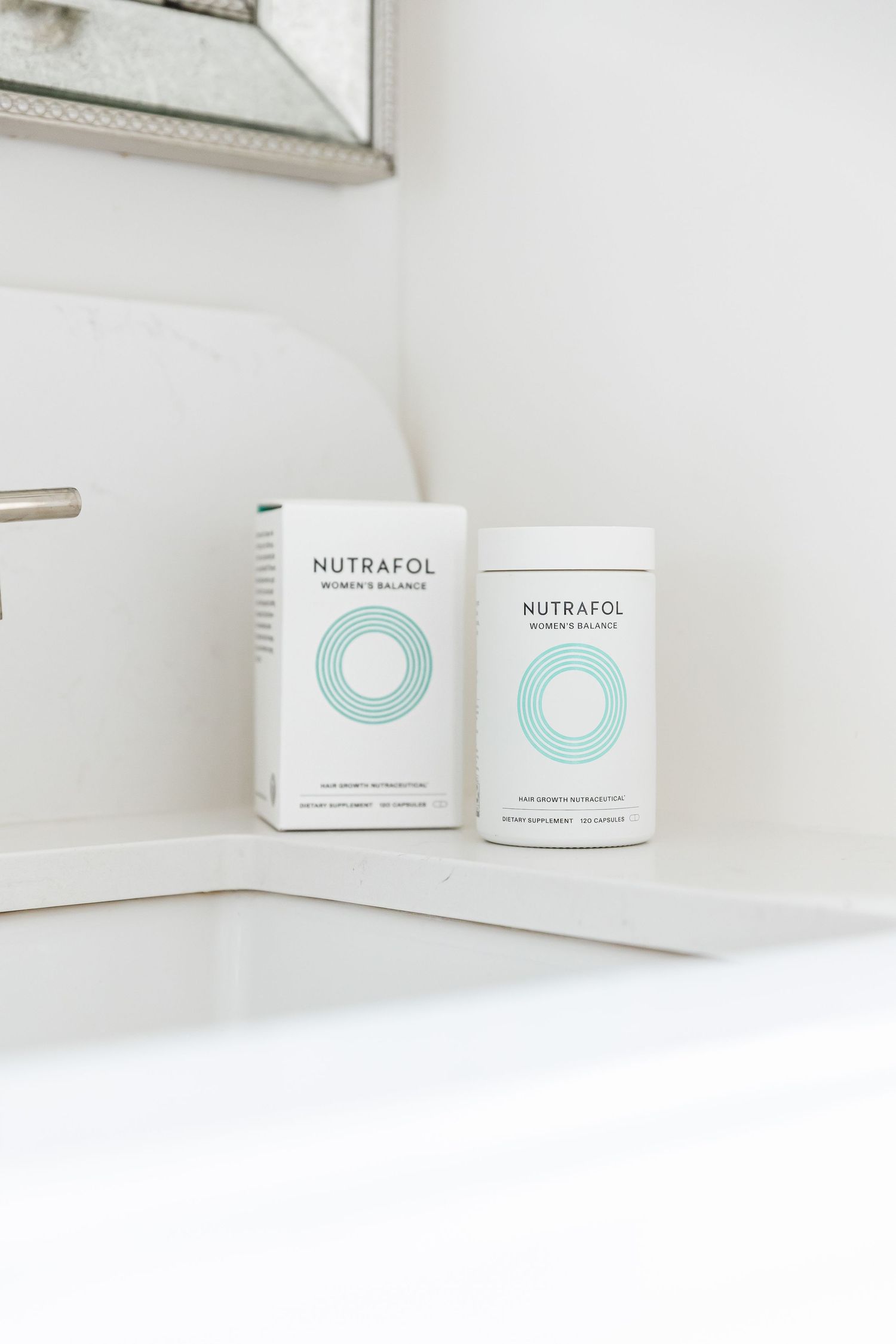 White minimalist skincare packaging for Nutrafol beauty products displayed on clean white surface.