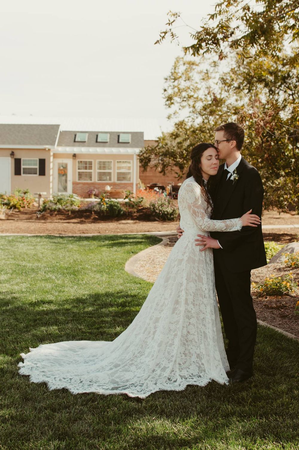A romantic outdoor wedding photo series showing a couple in formal attire embracing on a sunlit lawn.