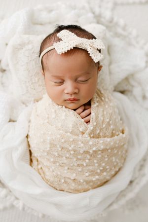 newborn baby wrapped in white basket