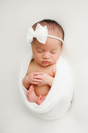 baby wrapped on white blanket