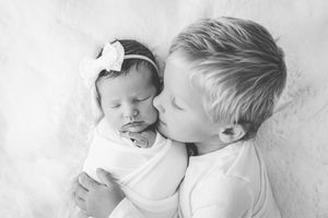 brother kissing newborn baby girl