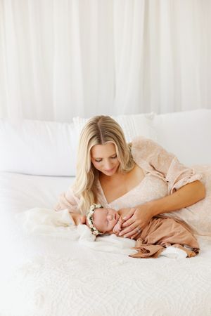 mom laying on bed with newborn baby girl