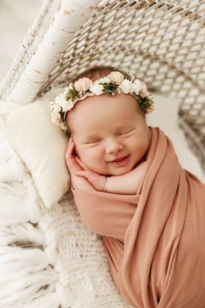 baby smiling in wicker chair