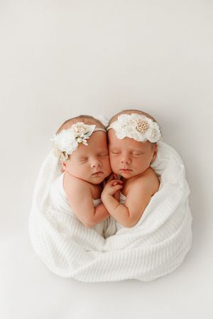 twin babies holding hands