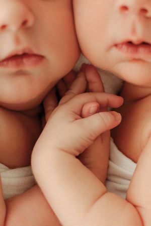 twin babies holding hands