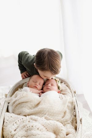 little boy kissing twin babies