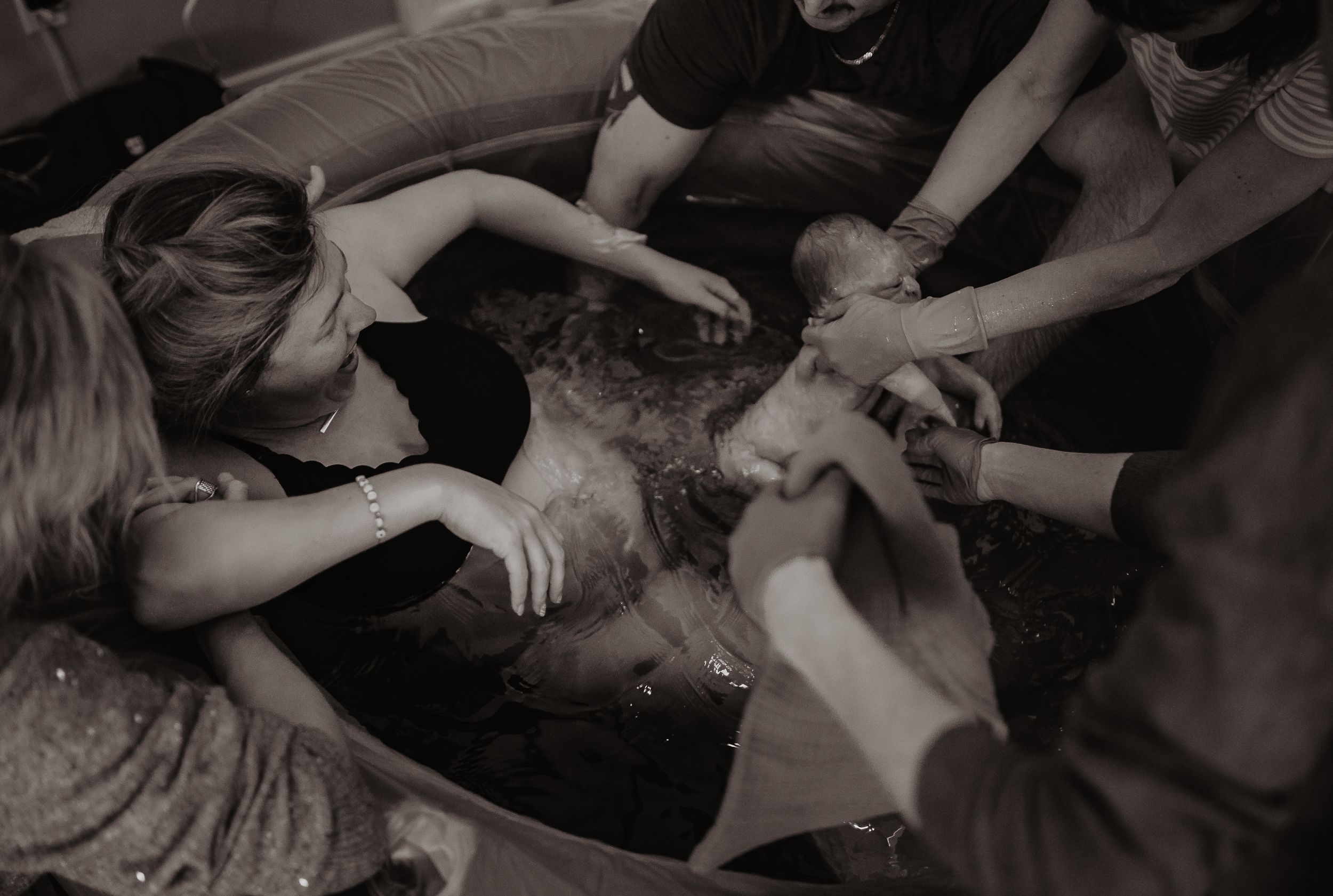 Group lying together in casual embrace on dark background.
