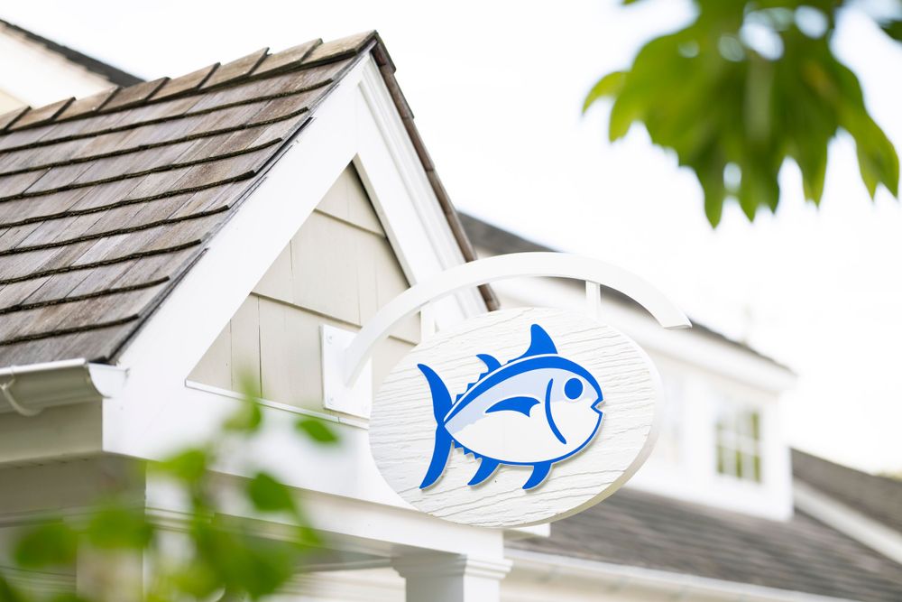 Blue and white fish logo sign mounted on white coastal-style building exterior.