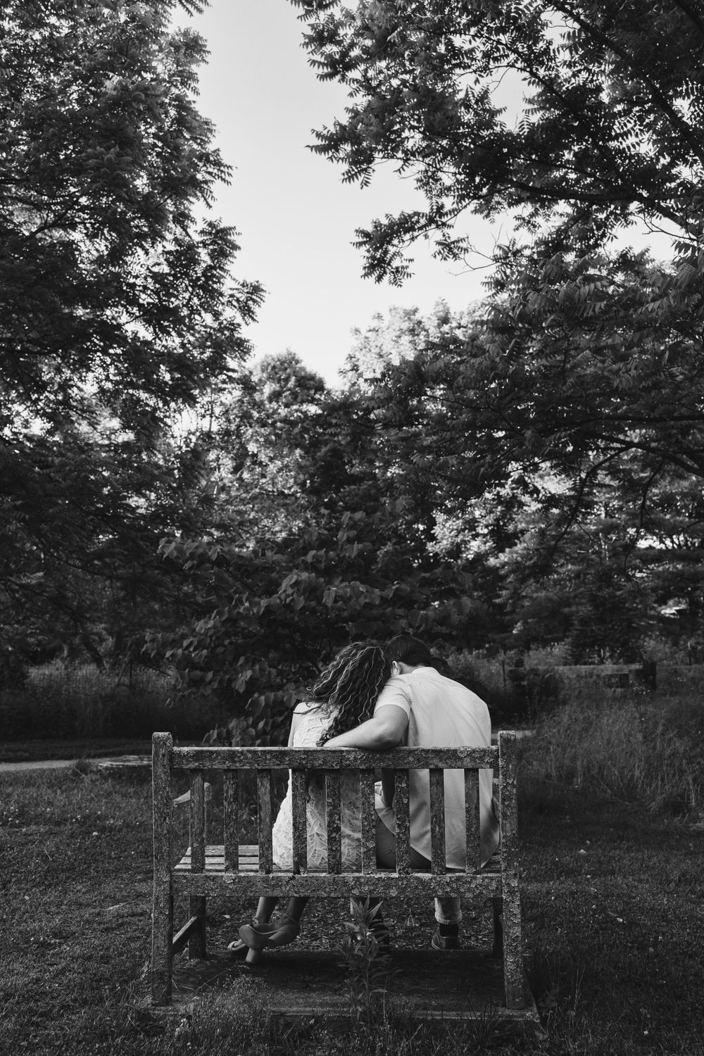 A series of black and white photos showing two people relaxing on a rustic wooden bench in nature.