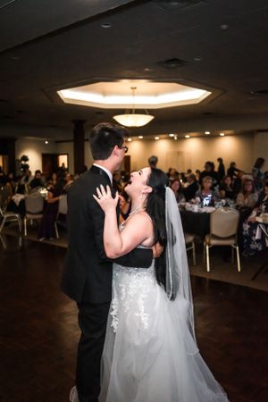 Couple's first dance under dramatic lighting at wedding reception venue.