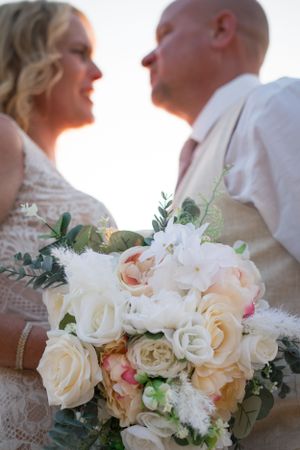A romantic sunset moment with a stunning bouquet of cream and blush roses in the foreground.