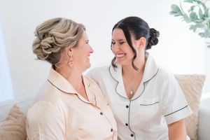 Two women in matching pajamas share a joyful moment together.