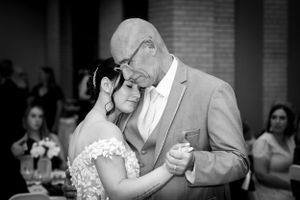 Black and white emotional father daughter dance at wedding reception.