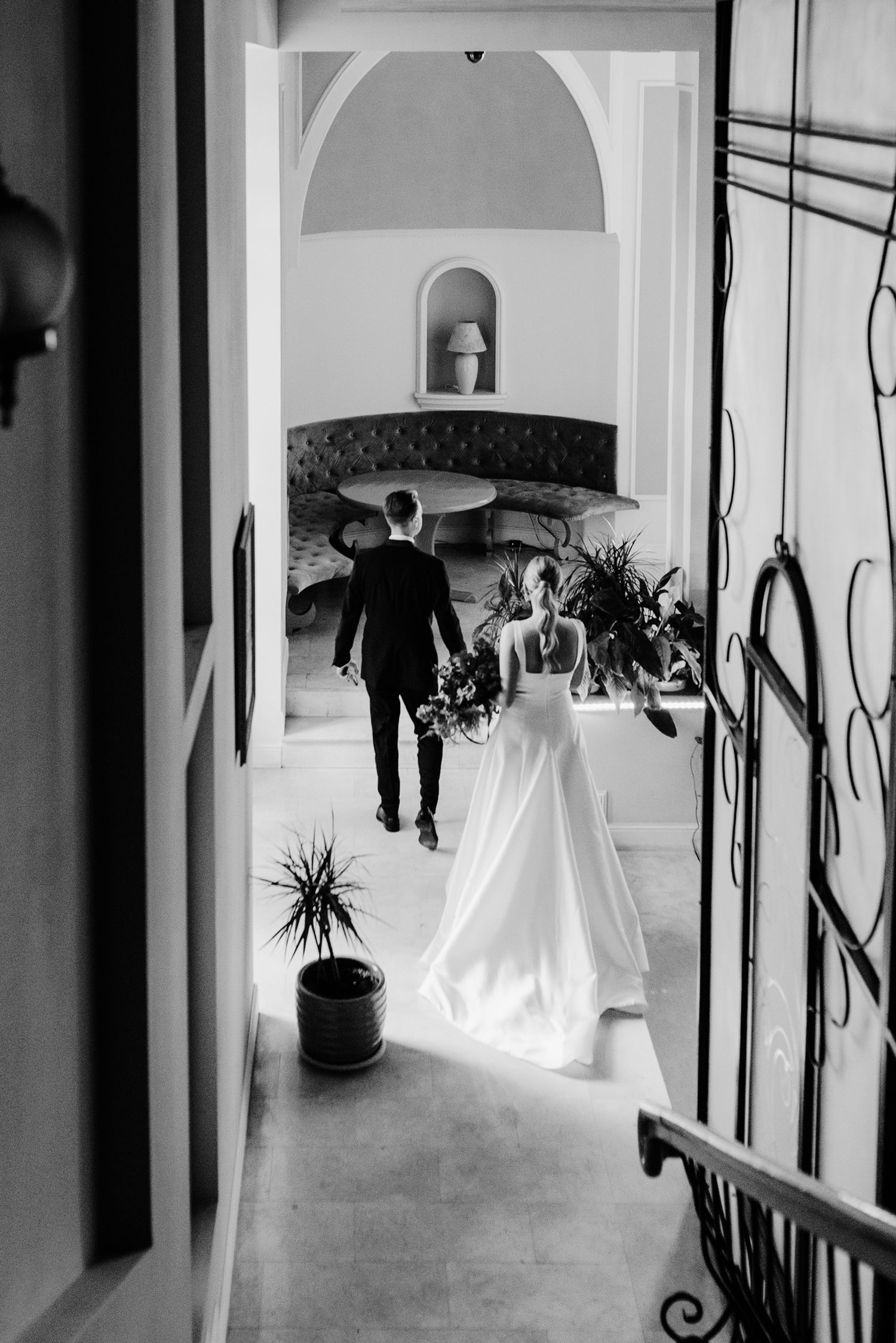 Black and white hallway with arched doorways and hanging decorative elements.