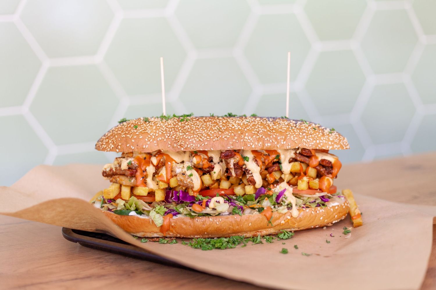 Long submarine sandwiches with various toppings on kraft paper background.