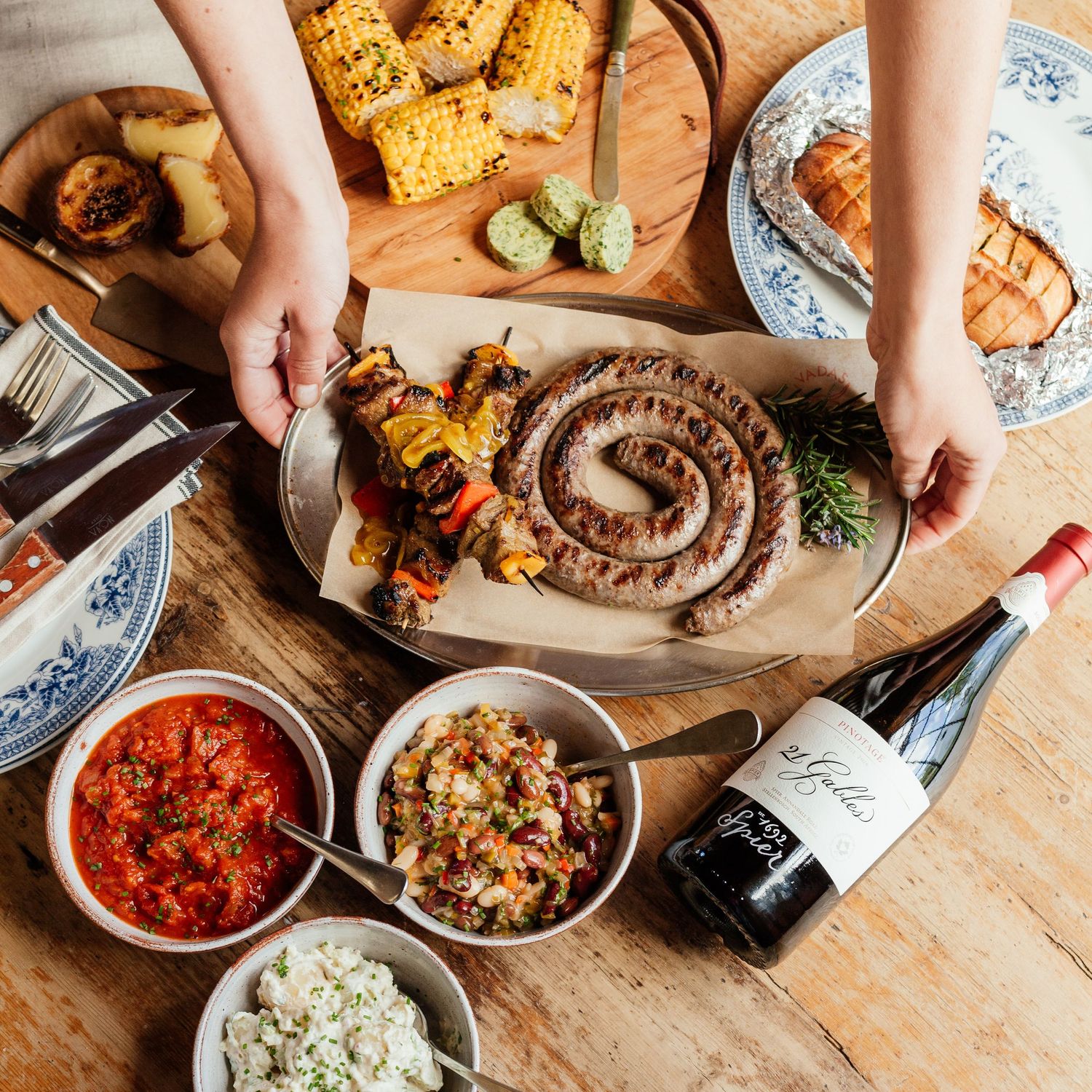 Various dishes and appetizers being served on wooden boards with colorful sauces and garnishes.