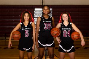 Three basketball players in black Warriors uniforms numbered 5, 32, and 24 pose together holding basketballs on a court.