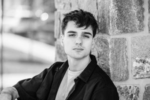 A black and white portrait series showing artistic headshots against a brick wall backdrop.