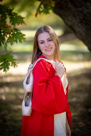 A series of sequential photos shows someone expressing joy while wearing a red sweater in an outdoor autumn setting.