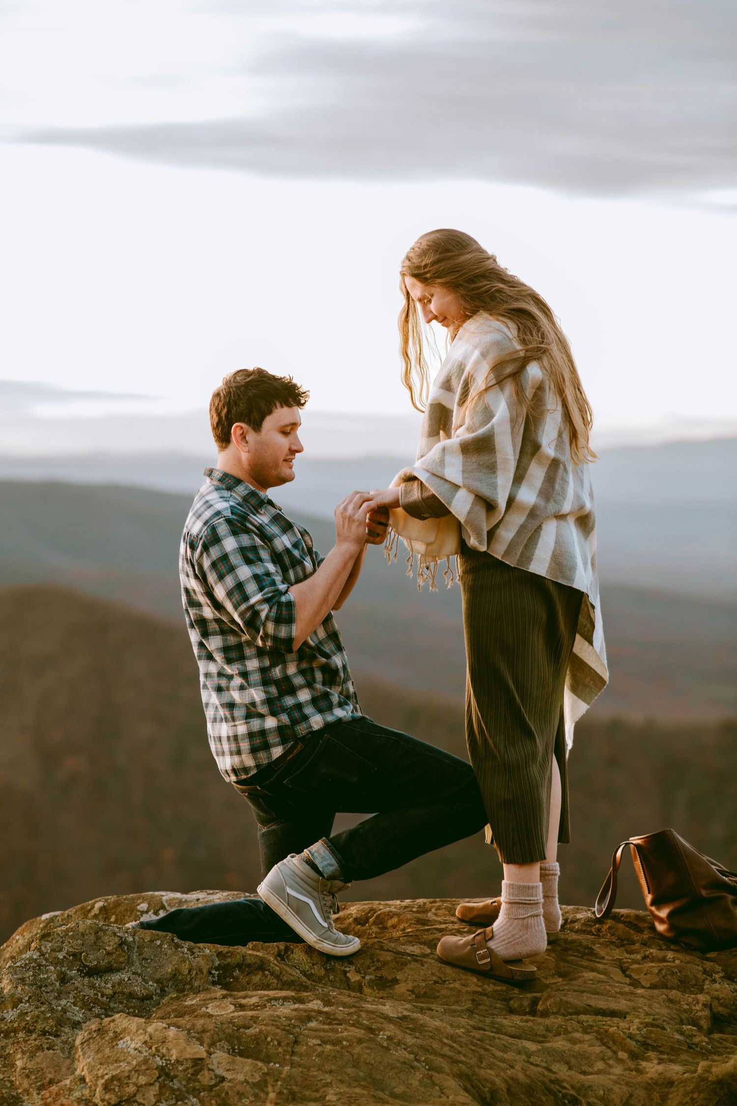 Man proposing to a woman and slipping a ring on her finger