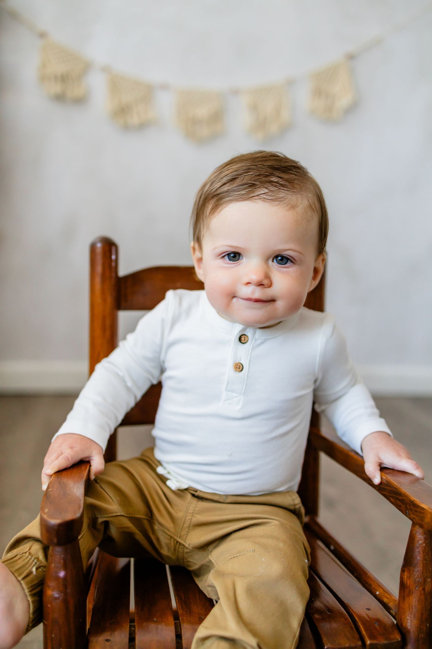 Baby is one year old sitting in a rocking chair, studio session