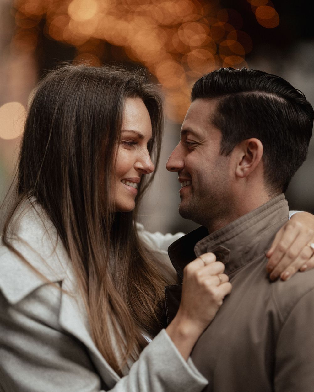 Intimate portrait of a couple sharing a tender moment with warm bokeh lighting in the background.