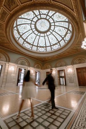 Interior panoramic view of ornate museum hall with geometric floor pattern and domed skylight ceiling.