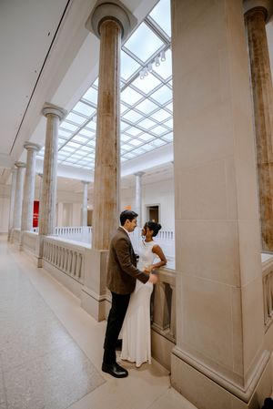 Architectural sequence showing elegant white columns and skylight in a bright minimalist gallery hallway.