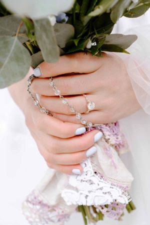 Close-up of a bride holding her bouquet, showcasing her ring and delicate details. Chicago wedding photographer