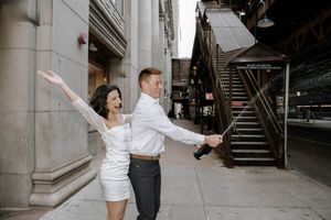 Couple dancing together under architectural columns in black and white photography.