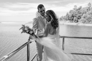 Black and white photo of a romantic moment at a waterfront wedding ceremony.