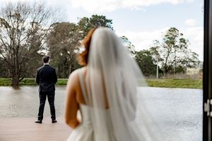 Couple walking along a tree-lined path during golden hour with autumn foliage and natural lighting.