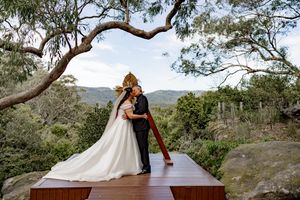 Romantic wedding photos captured against scenic mountain landscape with eucalyptus trees framing the shots.