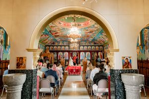 Interior panorama of an ornate Orthodox church with chandeliers, icons and painted ceiling decorations.